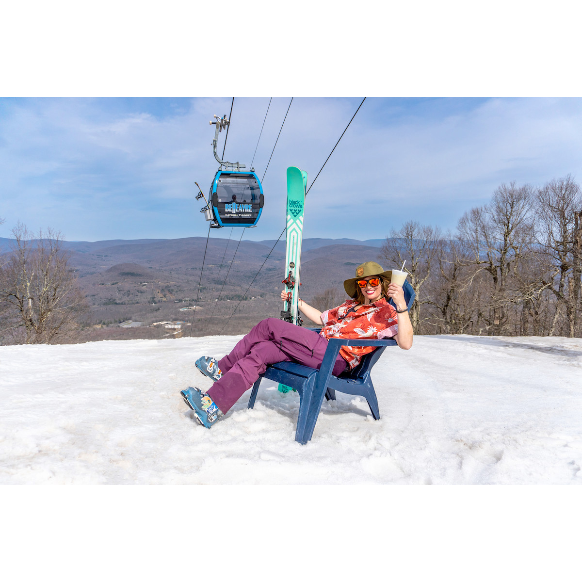 Person in chair on the slope with gondola in the background