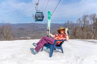 Person in chair on the slope with gondola in the background