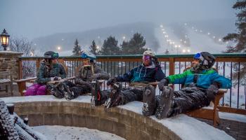 skiers around fire place outside 