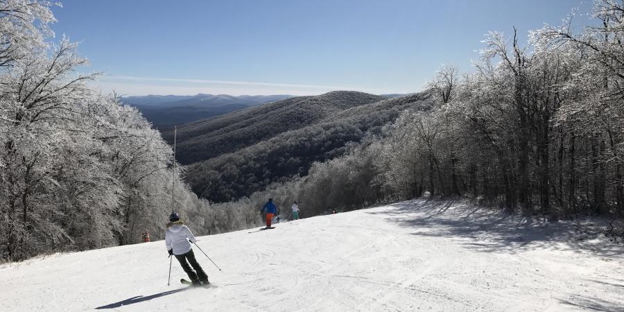 Skiers skiing down slope